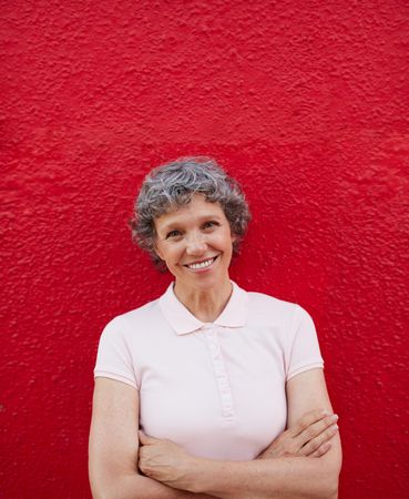 Portrait of happy woman standing against red background