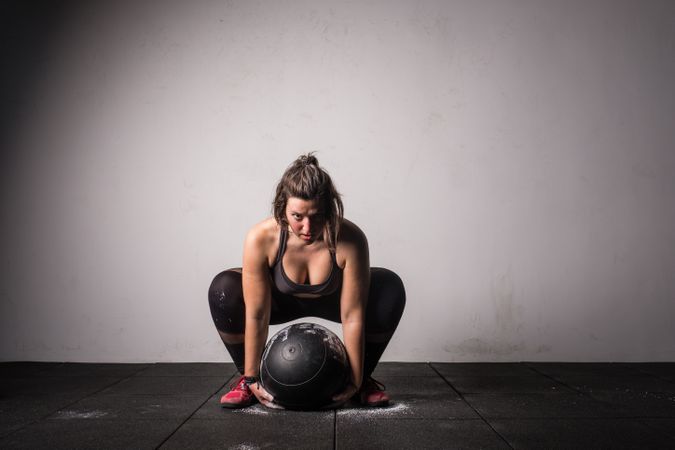 Woman lifting medicine ball in gym