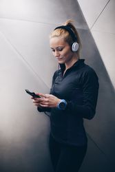 Woman with sportswear listening to music with headphones