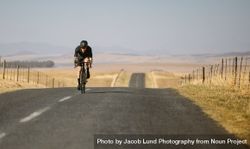 Male cyclist riding up a hill on road 5r9ka2