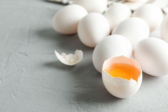 chicken eggs and kitchen towel on grey background, space for text and closeup