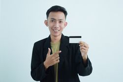 Asian businessman in suit and tshirt holding white credit card