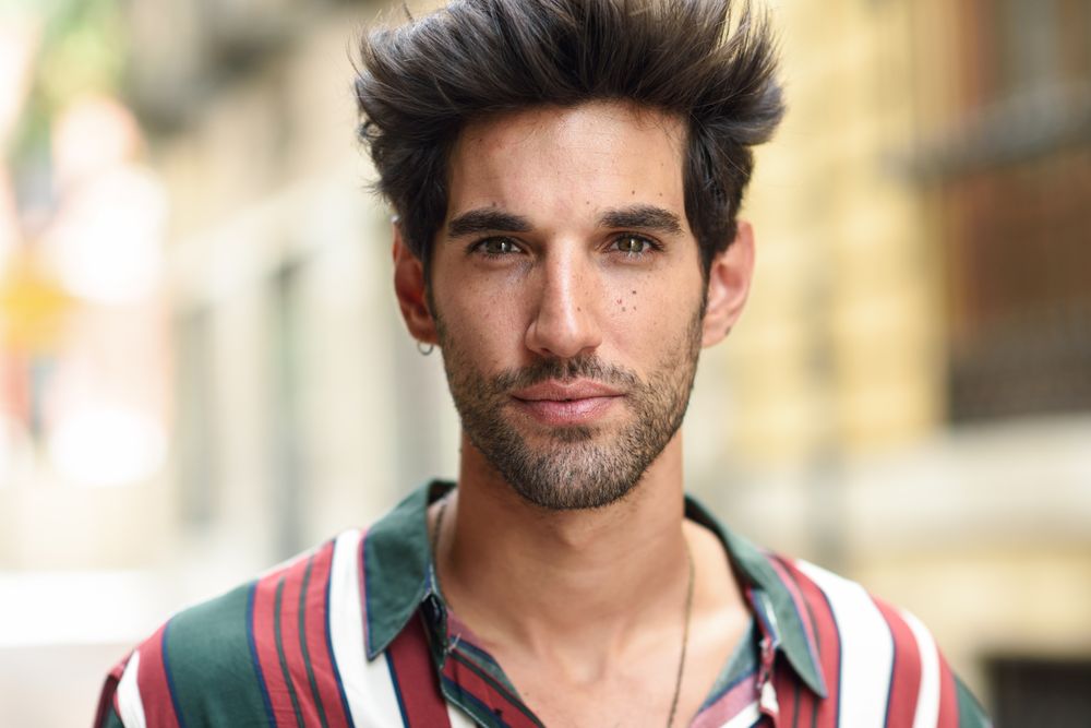 Portrait of intense man with dark hair outside