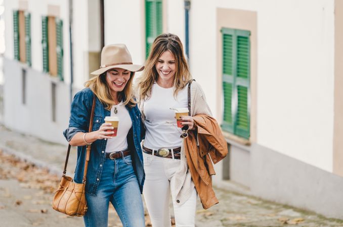 Women walking and chatting with cups of coffee
