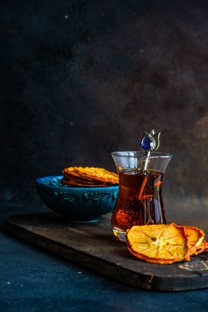 Side view of dried persimmon slices surrounding Turkish tea