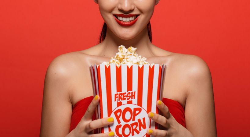 Close up of woman holding popcorn bucket