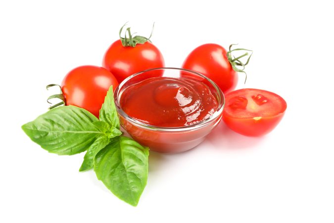 Fresh cherry tomatoes with basil and souce isolated on light background. Ripe vegetables