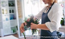 Skillful female florist creating bouquet of flowers 5kABQb