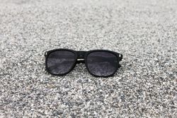 Sunglasses sitting on grey sand