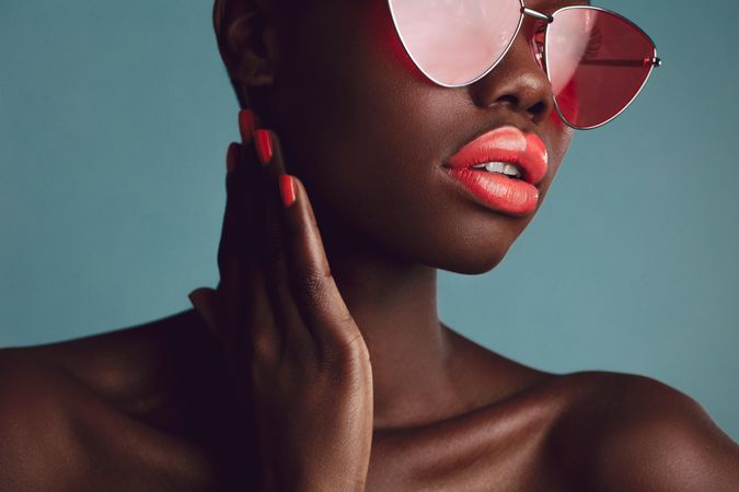Close-up of a glamorous female model with artistic makeup wearing funky sunglasses