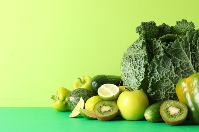 Vegetables and fruits on green background, copy space