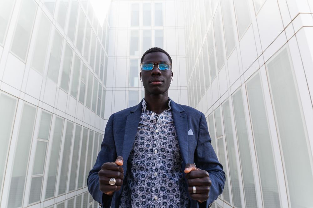 Content Black businessman listening to music in earbuds in city