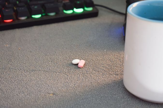 Two pills on desk in front of keyboard