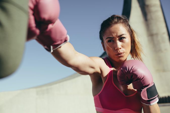 Sportswoman wearing boxing gloves training boxing