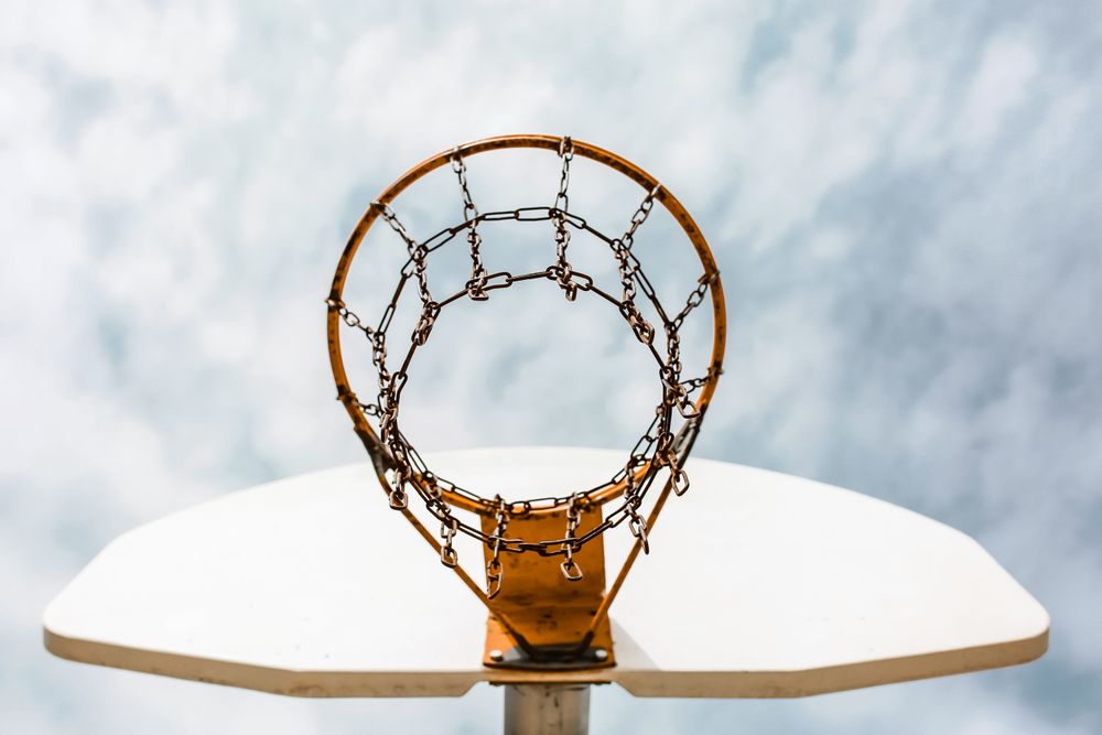 Ground view of a basketball hoop under cloudy sky