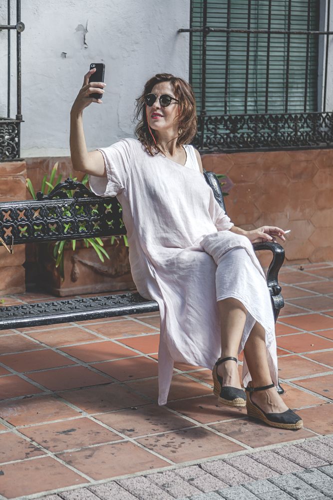 Female taking selfie with phone on street
