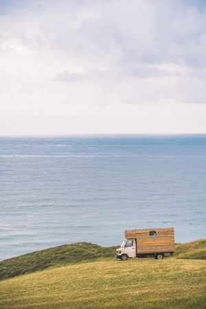Landscape of empty meadow with passing truck near seaside