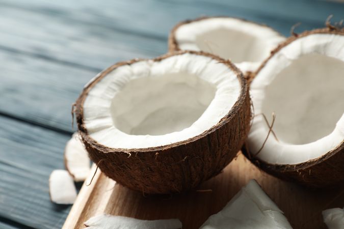 Board with coconut on wooden background, close up