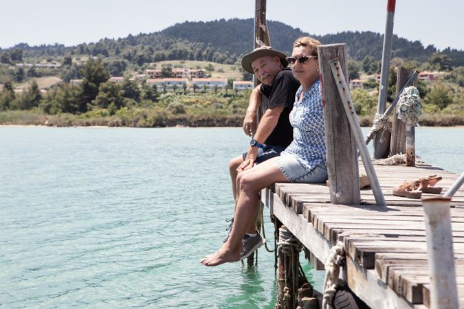 couple sitting on dock dangling with legs