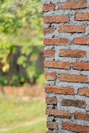 Half-collapsed brick wall with rough unfinished cement