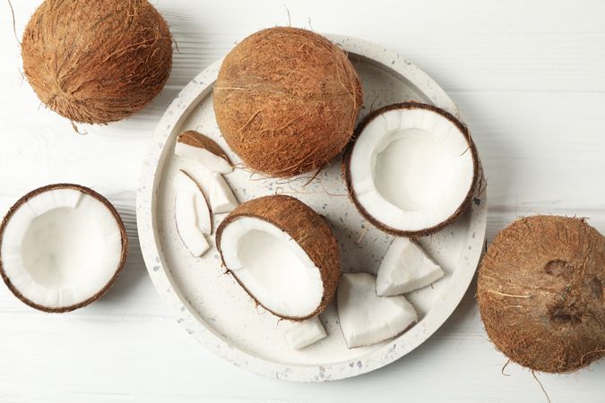 Tray with coconut on wooden background, top view. Tropical fruit
