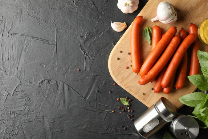 Wooden board with cured sausages, with garlic, copy space