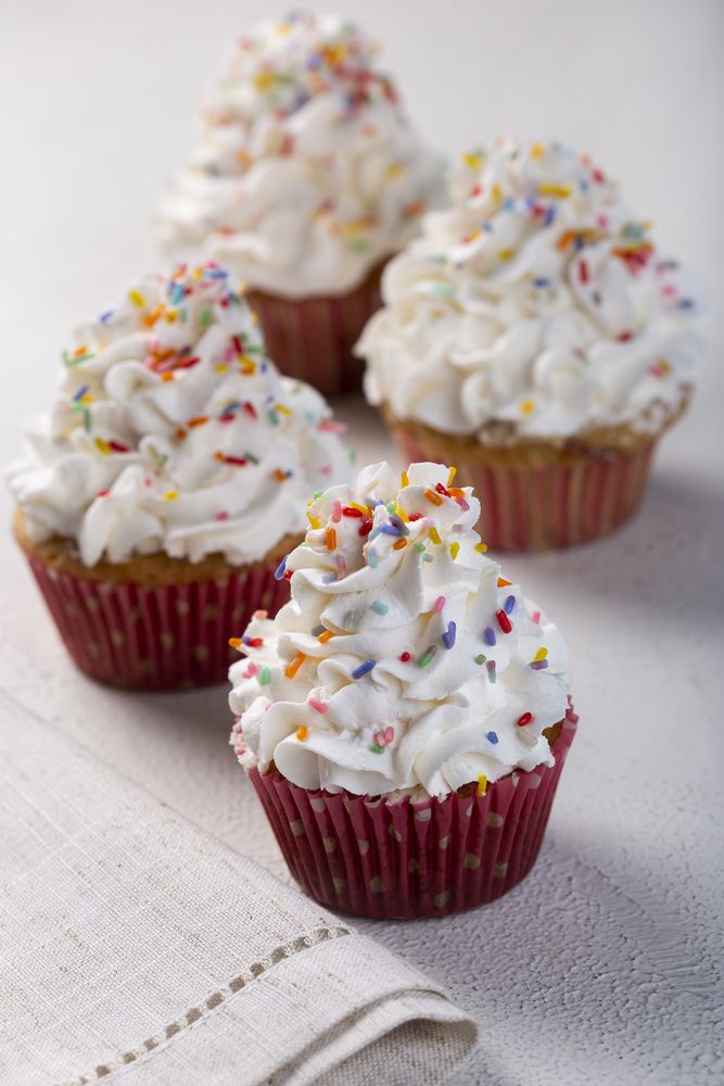 Tasty party cupcakes on the table. Cupcakes with whipped cream.