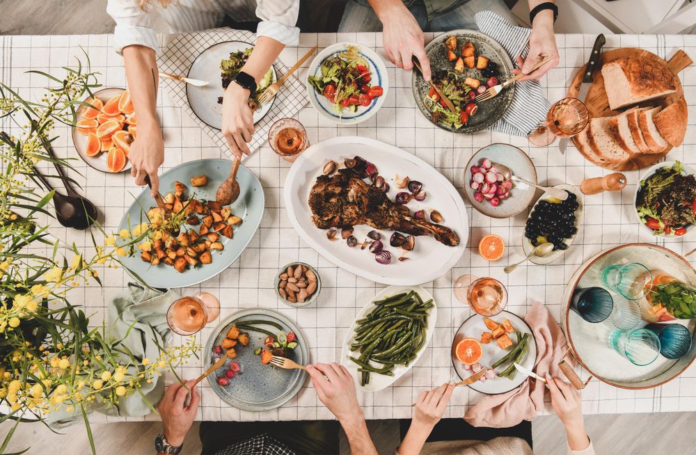 Flat-lay of Mediterranean table setting, with group of people at dinner table