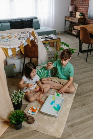 Children camping at home playing fishing game