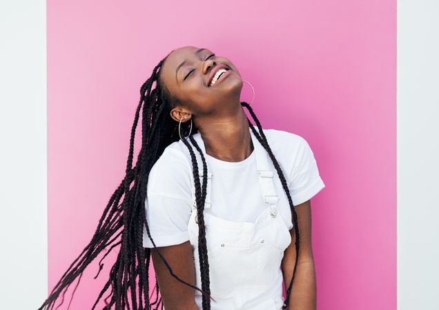 Black woman with long braids smiling with her head back