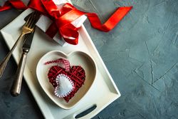 St. Valentine day table setting with heart plate and giftbox