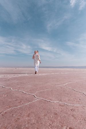 Thoughtful relaxed tourist enjoying unusual scenery of pink salt lake