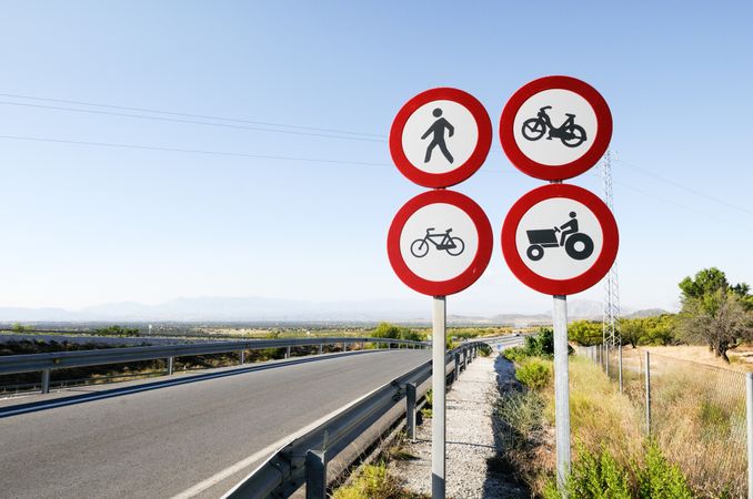 Four roadsigns on quiet road in rural Spain