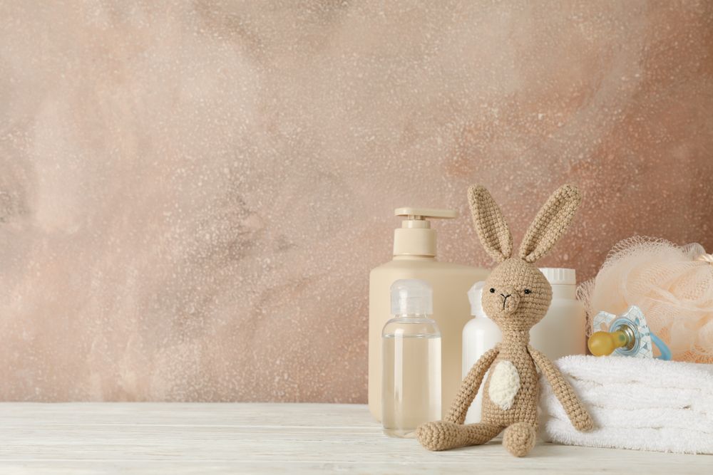 Baby hygiene accessories on wooden table against brown background