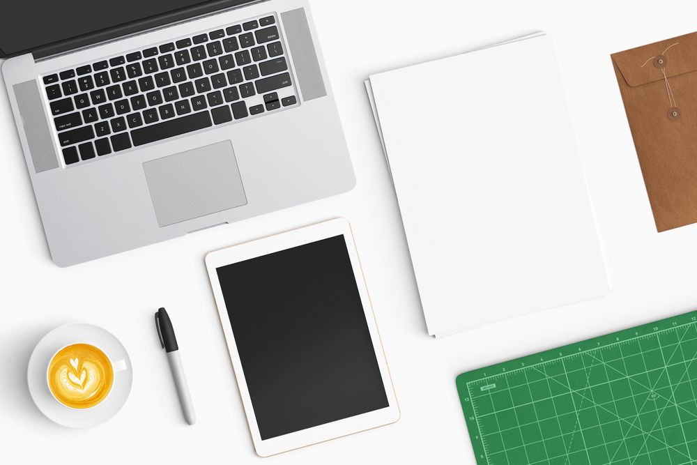Modern workspace with coffee cup, smartphone, paper, notebook, tablet and laptop copy space