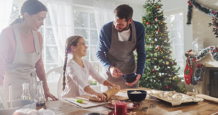 Portrait of Little Cute Girl Learning How to Make Cookies and Celebrating her Achievement with her Parents.