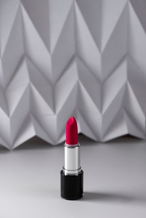 Pink lipstick on raised chevron. Product and make up contemporary concept