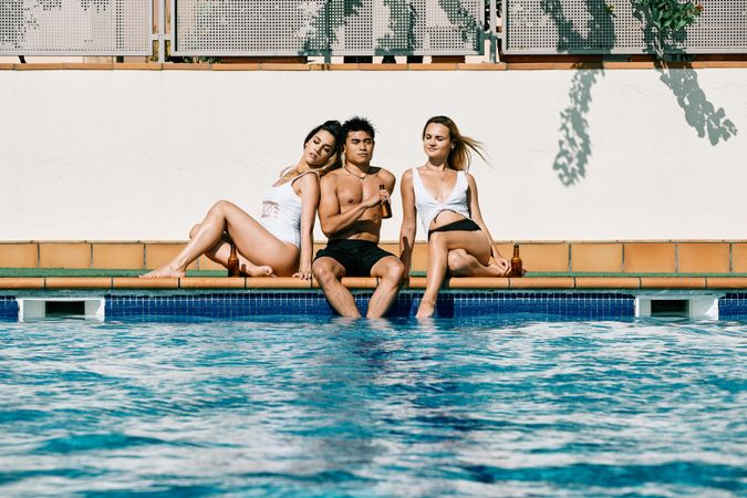 a group of young models by the pool in a summer day