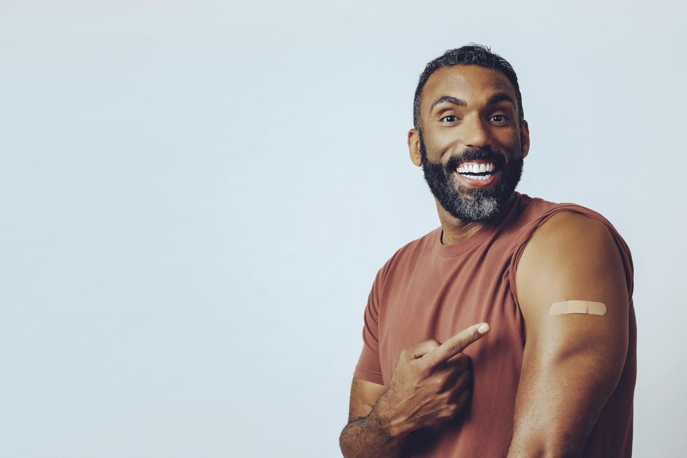 Proud man pointing at vaccination with copy space