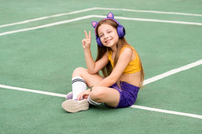 Female child waving from sports ground
