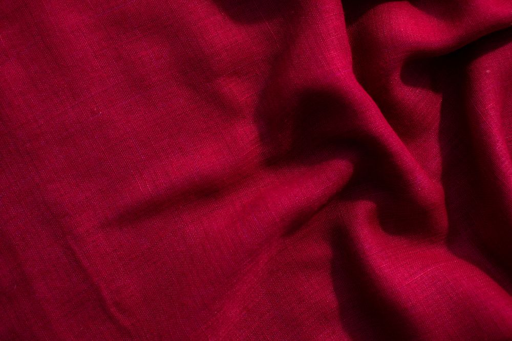 Red fabric wavy crumpled background texture with copy space.