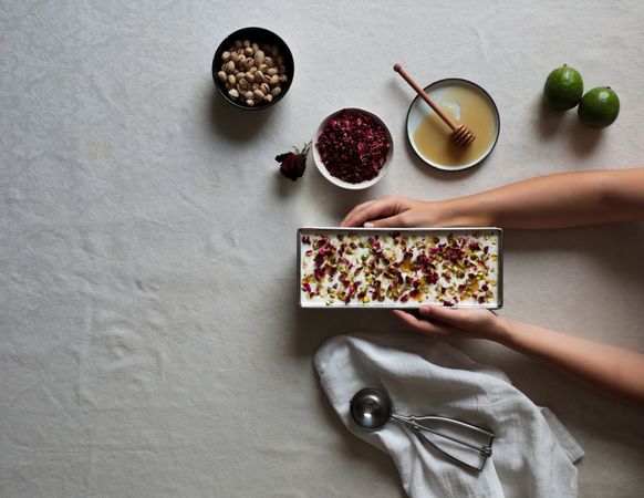 Crop hands putting cheesecake on table