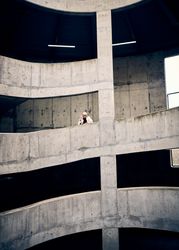 Young man posing on spiral parking structure
