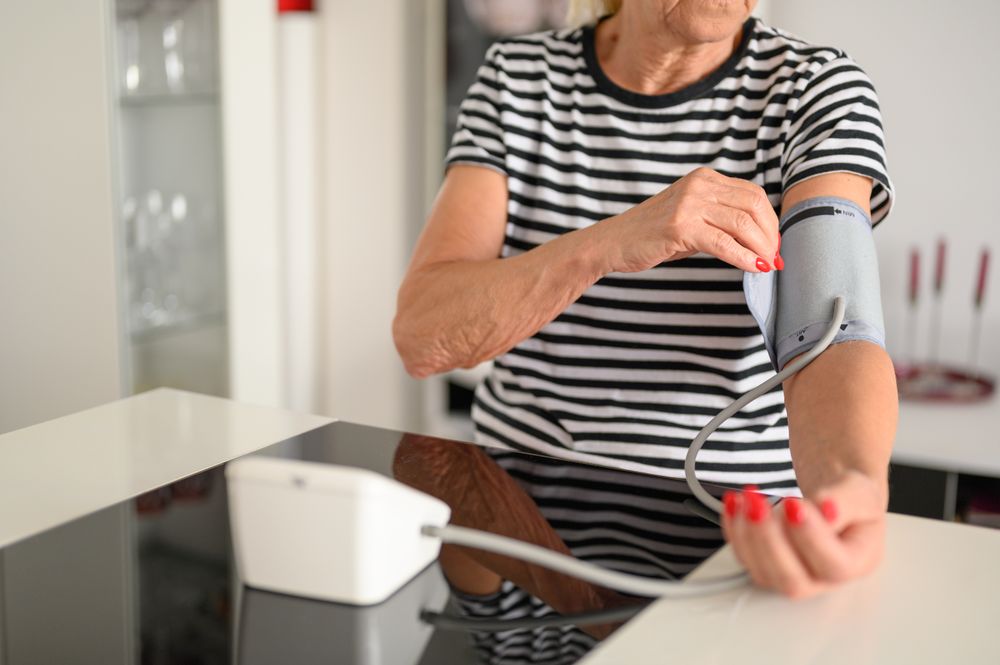 Crop of older woman measuring blood pressure