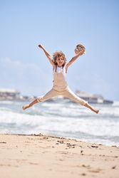 Carefree boy jumping on sandy beach