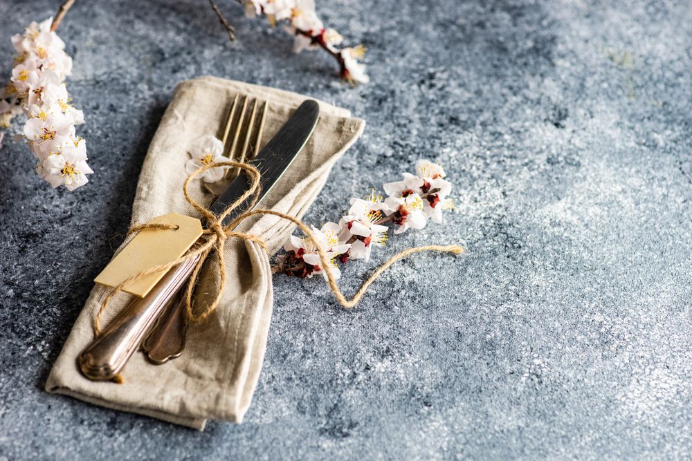 Spring floral concept with top view of apricot blossom branch wrapped in beige napkin