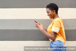 Laughing female checking phone in front of striped wall 0glPl5