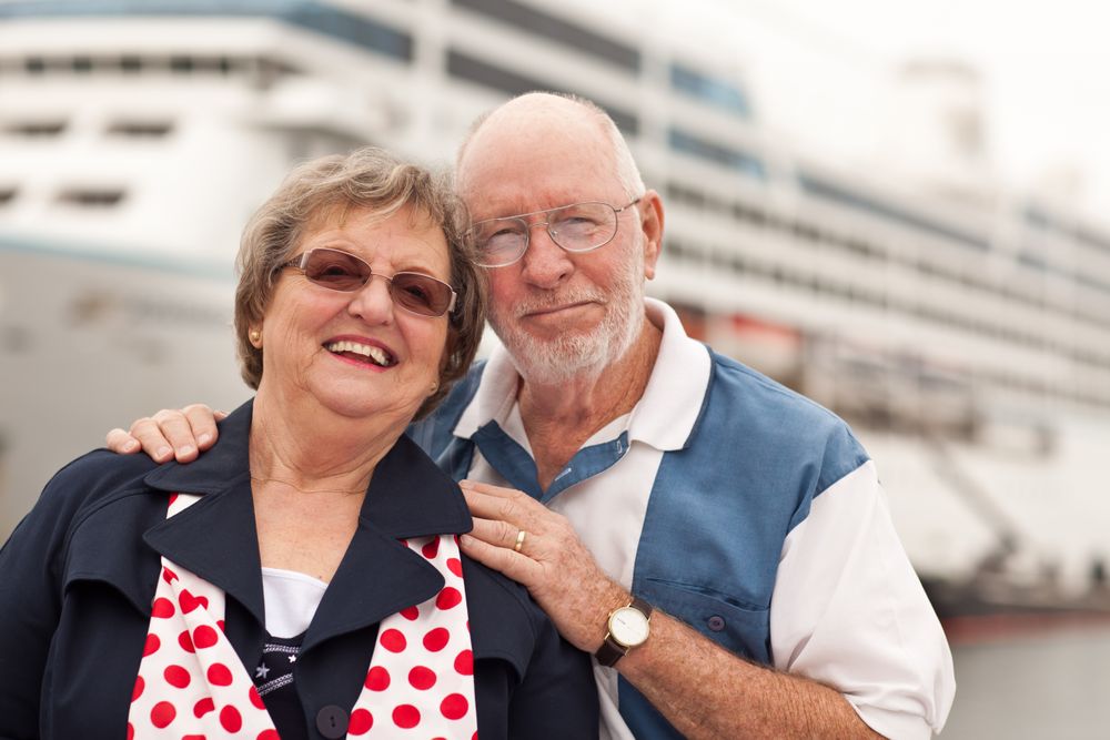 Older Couple On Shore in Front of Cruise Ship