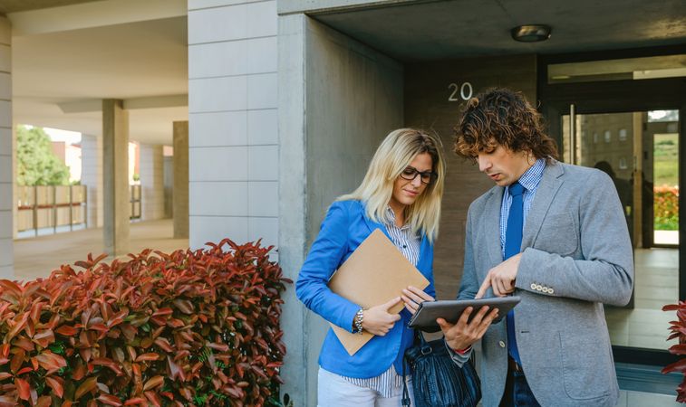 Businesspeople checking documents in the street