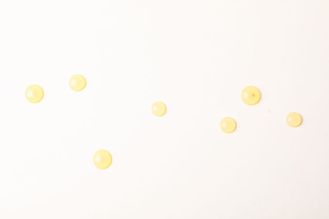 Honey drops on plain background, space for text